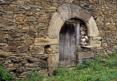 Jakobsweg (Camino Francés): Holztür in einer Steinmauer - Triacastela