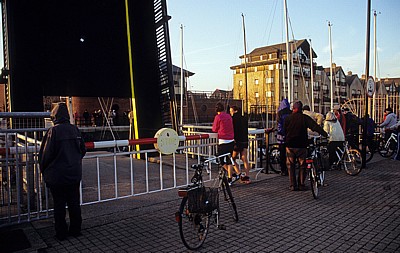 Schleuse zum Brunswick Dock: Fußgänger und Radfahrer warten vor dem geöffneten Schleusentor - Liverpool
