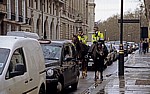 Berittene Bobbies warten zwischen den Autos an einer Ampel - London