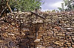 Jakobsweg (Camino Francés): Steinmauer mit Holzkreuz - El Ganso